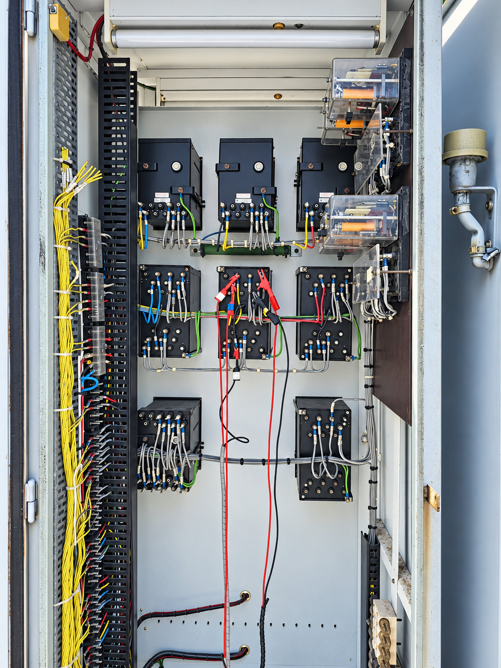 Protection relay panel with test leads connected during secondary injection testing